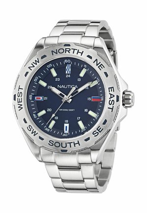 Montre Nautica avec un bracelet en acier inoxydable, un cadran bleu, des marqueurs lumineux et une lunette tournante comportant des étiquettes de directions cardinales.