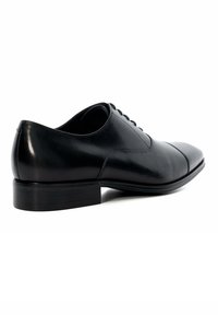 Black leather dress shoe with a rounded toe, smooth texture, flat sole, and a small heel, featuring subtle stitching details and lace-up closure.