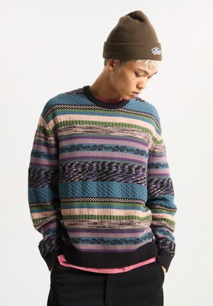Colorful knit sweater featuring horizontal stripes in blue, pink, green, and purple, with textured patterns and ribbed cuffs.