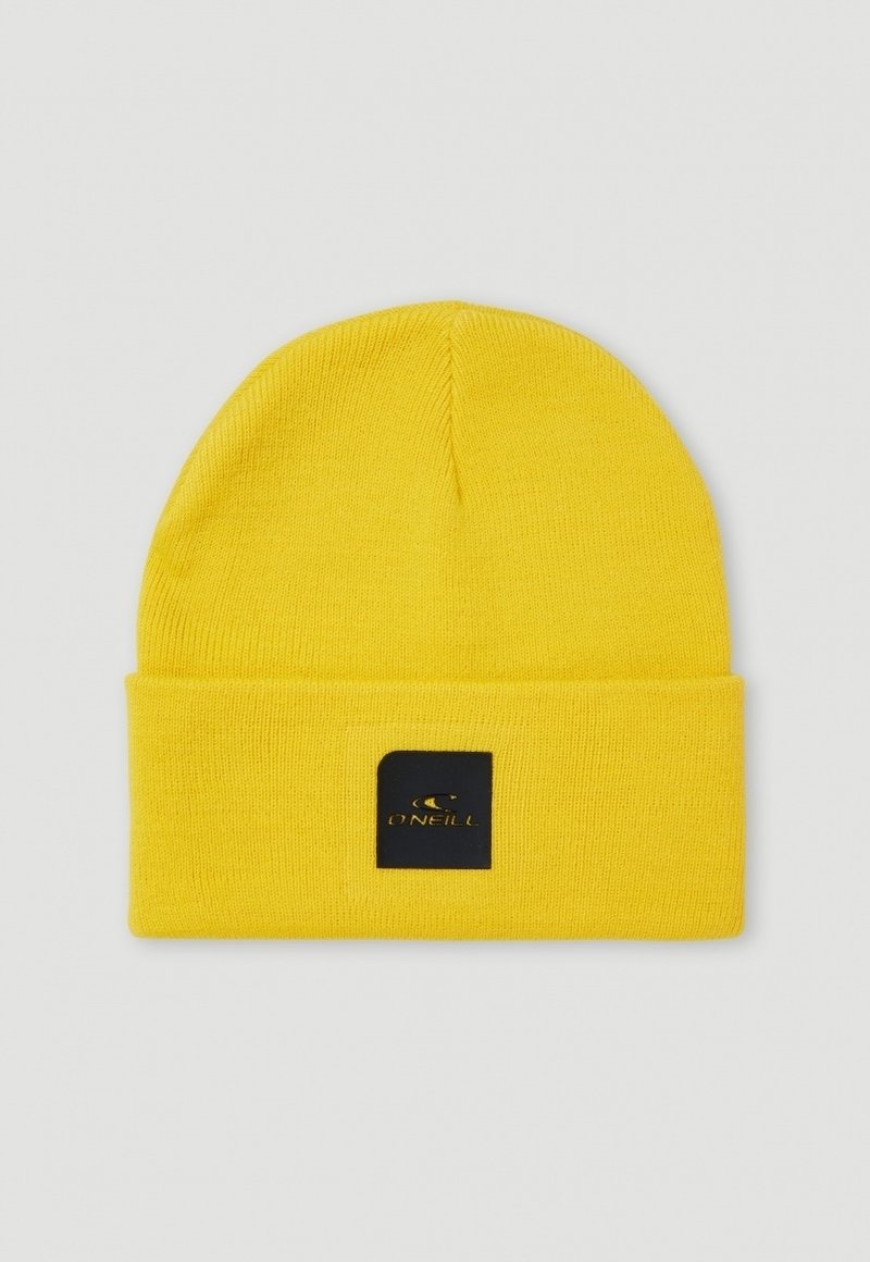 Yellow knitted beanie with a folded cuff, featuring a black square patch with the brand logo in gold. Smooth texture and close-fitting design.