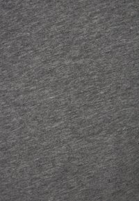 Grauer Stofftextil mit meliertes Textur, das sich weich und leicht anfühlt und subtile Farbvariationen aufweist.