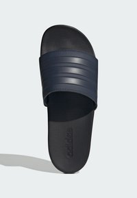 Navy slide sandal with a textured black footbed, featuring wide ribbed strap and embossed logo. Made from durable synthetic material.