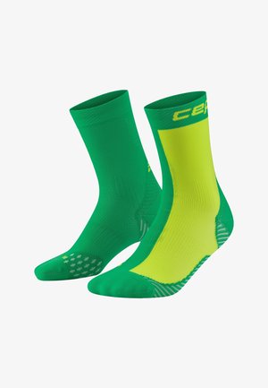 Groene en gele sportieve sokken met ribbels aan de bovenrand, een textuurgripzool en ventilatiezones; voorzien van een logo aan de zijkant.