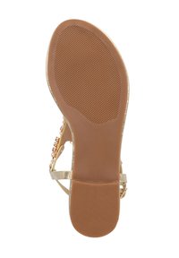 Sandale dorée à lanières avec une semelle en caoutchouc brun lisse, présentant un motif texturé et une lanière embellie avec des accents transparents et dorés.