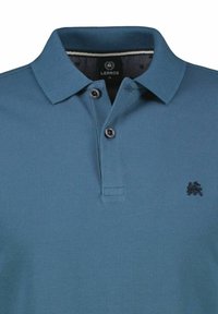 Short-sleeve polo shirt in dark teal, made from textured fabric. Features a three-button placket and a small embroidered logo on the chest.