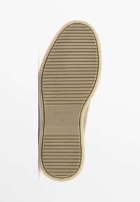 Semelle de chaussure beige clair avec des rainures horizontales, marquée "Massimo Dutti" et taille "42". Matériau plat, semblable au caoutchouc, sans motifs visibles.