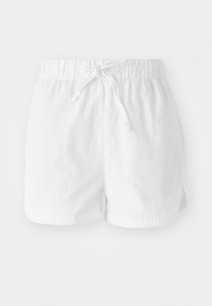 White cotton shorts with an elastic waistband and adjustable drawstring. Features side slits for mobility and a relaxed fit.