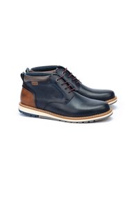 Navy leather ankle boots with brown accents, round toe, two-tone sole, and lace-up design. Features a logo tag on the side.