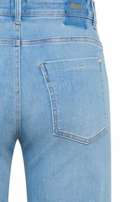 Jeans in denim azzurro chiaro con taglio classico, dotati di una tasca posteriore singola e dettagli di cuciture sottili. Logo marchiato sulla vita.