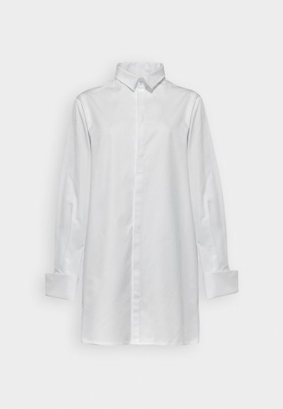 Vit långärmad skjorta i vävt tyg, med klassisk krage, knappstängning fram och vikbara manschetter. Slät textur utan mönster.