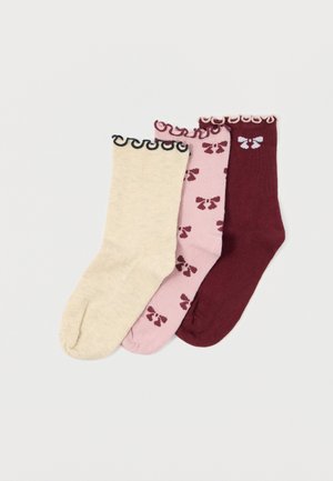 Drei Paare gestrickte Socken: beige, rosa mit Blumenmuster und burgunderrot. Jede hat einen dekorativen, gewellten Saum. Weicher Stoff.