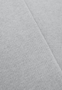 Lichtgrijze gebreide stof met een gladde textuur, een fijn, gelijkmatig patroon en een lichte rek, die een zachte en gezellige uitstraling heeft.