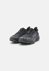 Zapatillas de running negras con un upper texturizado, acentos grises y un diseño con patrones. Suela gruesa para tracción y estabilidad.