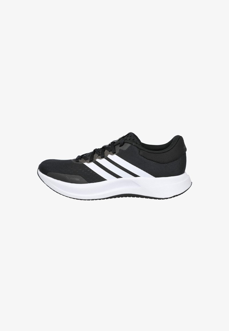 Zapatilla deportiva negra con rayas blancas, parte superior de malla, cuello acolchado y suela blanca. Presenta un diseño texturizado para ofrecer agarre y comodidad.