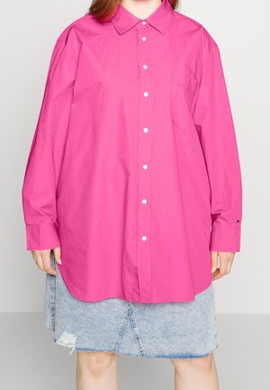 Rosa oversized skjorte med krave, frontknapper, venstre brystlomme og broderede detaljer. Sættes sammen med en falmet denimnederdel.
