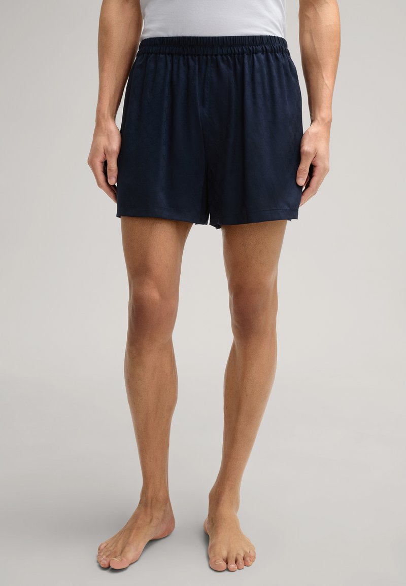 Shorts de bain bleu marine en tissu léger, dotés d'une taille élastique et d'une coupe décontractée, avec un motif texturé subtil.