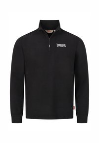 Czarny polarowy sweter z kołnierzem zapinanym na zamek, z małym białym logo na klatce piersiowej. Długie rękawy i prosty dół, z metką z boku.