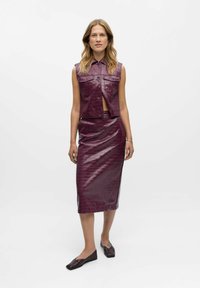 Violet leren mouwloos top met zakdetails, gecombineerd met een bijpassende kokerrok, beide met een gestructureerd krokodillenprint.