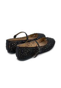 Ballerines noires ornées de perles avec une sangle. Présentent un dessus texturé orné de perles noires brillantes et une doublure intérieure lisse.