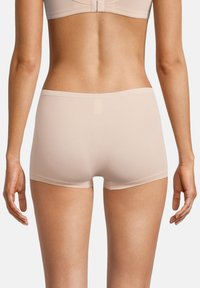 Beżowe hipsterskie majtki wykonane z miękkiego, elastycznego materiału. Posiadają gładką talię oraz minimalistyczny design, bez widocznych szwów czy wzorów.