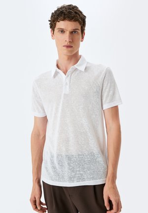 Hvid polo-shirt lavet af struktureret, semi-transparent stof, med en klassisk krave og tre-knaps lukning, korte ærmer og en afslappet pasform.