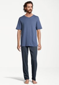 Heren slaapset bestaande uit een blauwe, kortebloemige V-hals T-shirt en donker gestreepte pyjamabroek. Katoenen materiaal, zachte textuur.