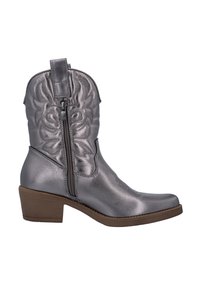 Botas de cowboy de color plateado metálico con costuras decorativas y una cremallera lateral, con una punta redonda y un tacón bajo y apilado de color marrón.