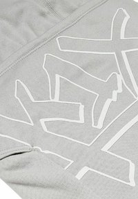 Gray hoodie featuring a white graphic design with bold, abstract lettering. The fabric has a smooth texture and elastic cuffs.