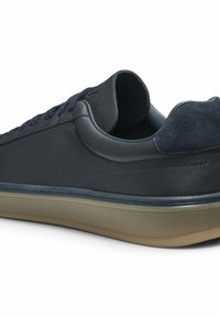 Marine leren sneaker met een gladde afwerking, suede accenten bij de hiel en een lichtgekleurde rubberen zool. Veters lopen aan de voorkant.