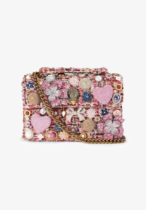 Piccola borsa a tracolla in tweed multicolore decorata con cuori rosa, spille floreali e gioiello, e una tracolla a catena dorata, su sfondo bianco.