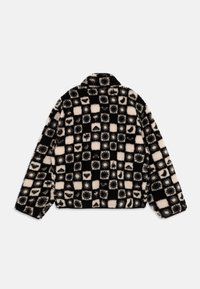 Chaqueta de forro polar con un patrón de tablero de ajedrez negro y crema con diversas texturas. Diseño con cuello, mangas largas y corte relajado.