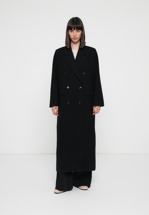 Black wool blend overcoat with a double-breasted design, wide lapels, and long sleeves. Features large buttons and a straight silhouette.