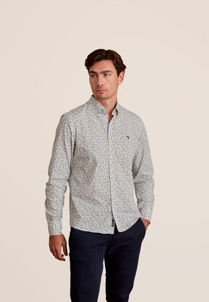 Overhemd met knoopsluiting op een witte basis, voorzien van een kleurrijk bloemenpatroon. Gemaakt van stof met een gladde textuur en een klassiek kraagontwerp.