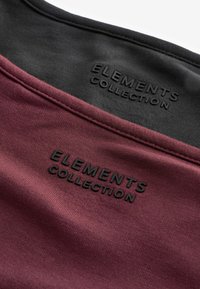 Bordeaux og sort tekstil med en glat tekstur, der har præget "ELEMENTS COLLECTION" branding. Skæring, der viser stoflag og syninger.