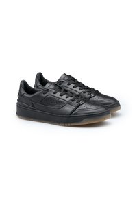 Un paio di sneaker in pelle nera con lacci, dettagli perforati e suole in gomma scura su uno sfondo bianco.
