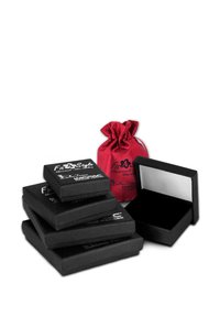 Des boîtes à bijoux noires avec des surfaces texturées empilées à côté d'une boîte ouverte, accompagnées d'un sac en satin rouge à cordon.