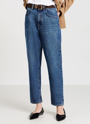 Light blue high-waisted jeans in denim with a straight fit, featuring a front zipper, five pockets, and subtle fading. Paired with black flats.