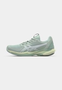 Chaussure de sport vert clair avec une tige en maille, des accents renforcés et une semelle en caoutchouc flexible. Présente un logo blanc et un design épuré.