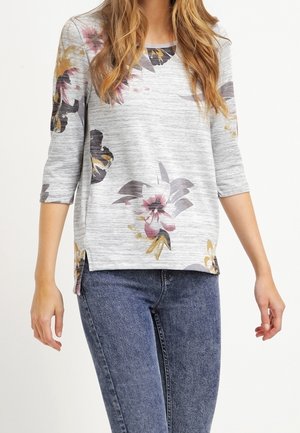 Grau gestricktes Oberteil mit floralen Mustern, drei Viertelärmeln und seitlichen Schlitzen, das pinke und gelbe Akzente im Design aufweist.