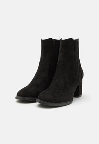 Bottines en daim noir à bout rond et talon empilé. Dotées de fermetures éclair verticales latérales et de détails de couture discrets.