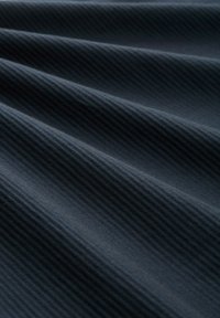 Strukturierter dunkler Stoff mit diagonalen Rippmustern, die unterschiedliche Blautöne und eine glatte Oberfläche zeigen.