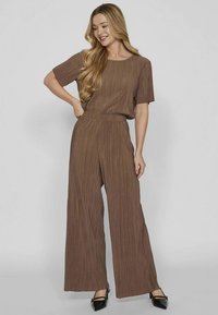 Completo marrone a due pezzi con pieghe, composto da una maglia a maniche corte e pantaloni a gamba larga, realizzato con una comoda fascia elastica in vita.