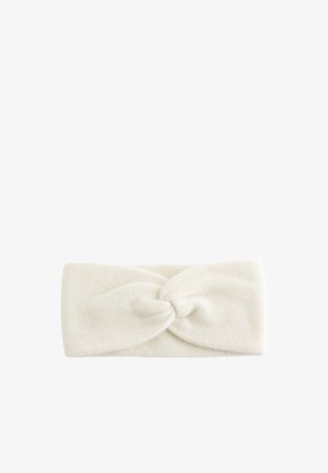 Bandeau en tricot dans un tissu crème doux avec un détail de nœud torsadé à l'avant. Forme rectangulaire, texture lisse.