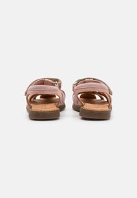 Rosa lærsandaler med semsket finish, åben design, justerbare stropper og en brun gummisål. Har en struktureret indersål for komfort.