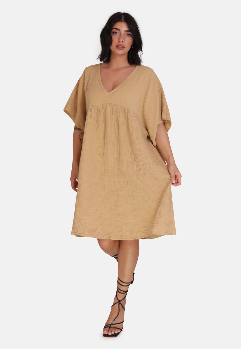 Robe beige mi-longue en tissu texturé avec un décolleté en V et des manches courtes amples, présentant un corsage froncé et un ourlet droit.