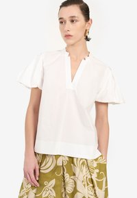 Weiße kurzärmelige Bluse mit V-Ausschnitt, aus leichtem Stoff, mit Puffärmeln und geradem Saum.