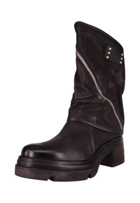 Bota de cuero negro para tobillo con diseño holgado, cremallera lateral y detalles con tachuelas. Cuenta con un tacón grueso y una superficie texturizada.