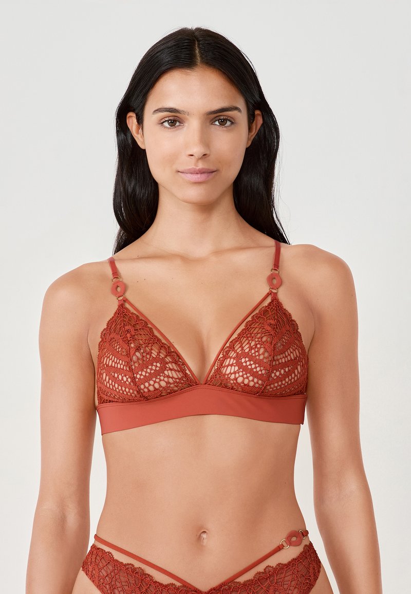Rode kanten bralette met een driehoekige vorm, voorzien van verstelbare bandjes en ronde hardwareaccenten. De gladde onderband biedt ondersteuning.