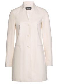 Abrigo blanco tipo camisa, hecho de tejido texturizado, con un cuello alto y dos bolsillos frontales, y cuatro botones redondos en la parte delantera.
