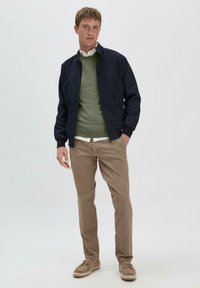 Marine bomberjack, olijfgroen trui, witte coll shirt, beige chino's en tan instappers. Eenvoudig ontwerp met gladde texturen en neutrale kleuren.